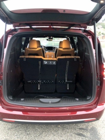 ><p>2nd row babysitter</p><p>The UConnect Theater Package included a 10.1-inch touch screen for 3D GPS navigation and the rear view camera display which includes the FamCam for easy viewing of rear seat passengers. The great sounding Harmon Kardon audio system, with a 10-inch rear subwoofer and 20 amplified speakers, backs up the AM/FM/HD, with SiriusXM (six-month subscription included.) You also get Siri Eyes Free, Alexa, Apple Car Play and Android Auto connectivity, Aux-in jacks, multiple USB ports, 115-volt power outlet and Bluetooth streaming audio and hands-free telephone. The 4G LTE Wi-Fi is a must for keeping those second-row passengers occupied (and quiet) on long family road trips.</p><p>Another nice touch on the dash, which opens-up cockpit space and reduces clutter, are the gear selector (a large wheel) and the electronic parking brake (piano switch), located side-by-side and next to the radio knobs. The well thought-out dash is elegant in its design, as is the complete interior.</p><h3>Second and Third Row: The Little Things</h3><img width=